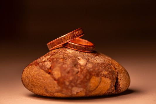 The process of making two copper wedding rings with a wooden inlay.